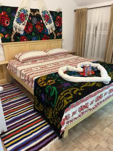 a bedroom with a bed with a bed frame and a blanket at Casa La Bella Vista in Moisei