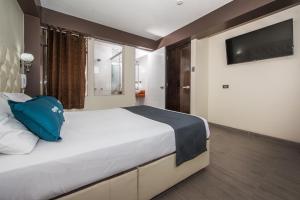 1 dormitorio con 1 cama grande y TV en Olimpo Hotel Sauna & Spa, en Cusco