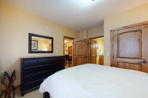 a bedroom with a bed and a dresser and a mirror at Aspens 4406 in Big White
