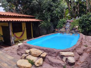 a swimming pool with a fountain in a yard at Hospedaria Raízes da Serra in Serra do Cipo