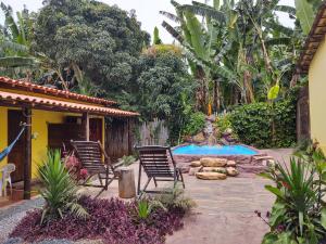un patio trasero con 2 sillas y una piscina en Hospedaria Raízes da Serra, en Serra do Cipo