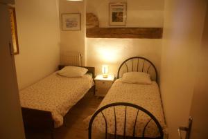 Habitación pequeña con 2 camas y lámpara en Moulin des sablons vakantiehuis gite en Malétable