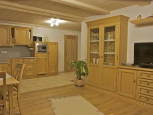 eine Küche mit Holzschränken und einem Flachbild-TV in der Unterkunft Ferienwohnungen Bauregger - Chiemgau Karte in Inzell