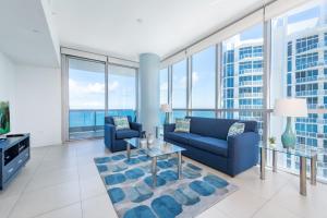 a living room with blue furniture and large windows at Churchill Suites Monte Carlo Miami Beach in Miami Beach