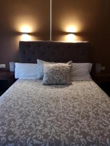 a bedroom with a large bed with two pillows at Hostal Plaza in Segovia