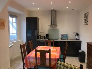 a kitchen with a table and chairs and a kitchen with a stove at Appartement - Villa " FERGINE" in Le Touquet-Paris-Plage