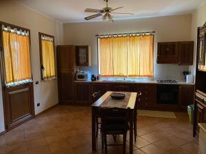 a kitchen with a table and a ceiling fan at Villa Piruzzu CV Torre Mulinazzo app P in Cinisi