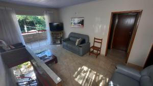 - un salon avec un canapé et une télévision dans l'établissement Eco-Residencial Martins, à Apiaí
