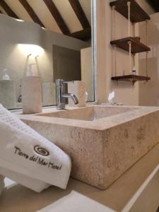 a large stone sink in a bathroom with a mirror at Tierra del Mar Hotel - Adults Only in Holbox Island