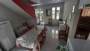 a room with a table and chairs and a kitchen at Eco-Residencial Martins in Apiaí