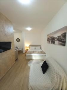 a bedroom with a bed and a couch at CASA APARTMENTS, one-bedroom apartment in Budva