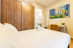 a bedroom with a large white bed and a wooden cabinet at Casa Danubio near Reforma by VH in Mexico City