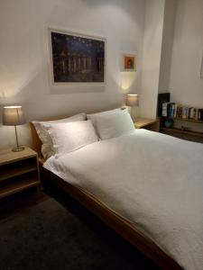 a bedroom with a large bed with white sheets and pillows at Great room in cool house in York