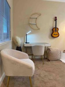 a room with a desk and a chair and a guitar at Balmoral in Santa Clara
