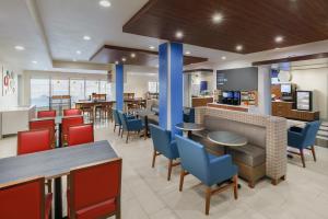 a restaurant with tables and chairs and a bar at Holiday Inn Express & Suites Oakhurst-Yosemite Park Area by IHG in Oakhurst