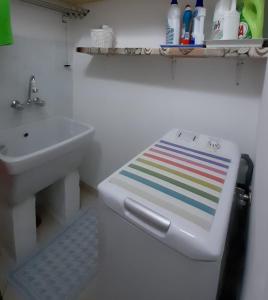 a bathroom with a sink and a toilet with a colorful stool at Radici Blu intero alloggio in Siderno Marina