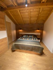 ein Schlafzimmer mit einem Bett in einem Zimmer mit Holzdecken in der Unterkunft Villa Lake House in Mavrovo-Nationalpark