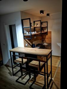 - une cuisine avec une table, des chaises et un évier dans l'établissement Apartman Mali Raj Zlatar, à Nova Varoš