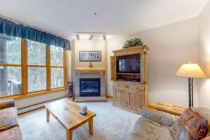 a living room with a couch and a tv and a fireplace at Trappers Crossing 8763 in Keystone