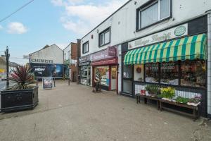 a group of shops on the side of a street at Lovely 2 bed Apartment with Parking in Thurrock in South Ockendon