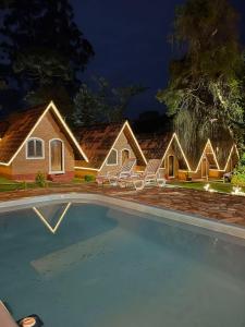 a house with a swimming pool at night at Pousada Vale Verde in Monte Verde