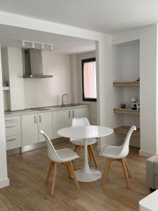 a kitchen with a table and two chairs and a table at Apartamentos Cisneros in Alicante