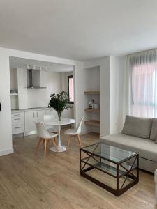 uma sala de estar com um sofá e uma mesa em Apartamentos Cisneros em Alicante