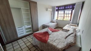 a small bedroom with a bed and a mirror at Aconchegante Apt FRENTE AO MAR in Barra de São Miguel
