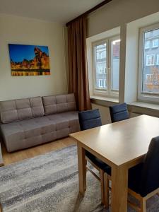 グダニスクにあるApartament Gdańsk Starówkaのリビングルーム(ソファ、テーブル付)