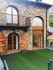 a stone house with a green lawn in front of it at P&C Agols in Encamp