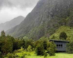 a building in front of a mountain at Base Puelo in Cochamó