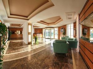 a lobby with green chairs in a building at Monte Carlo Palace Rooms in Bucharest