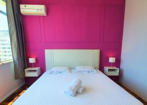 Un dormitorio con una pared rosa y una cama en Mar, Lagoa, Vista Incrível em Ipanema, en Río de Janeiro