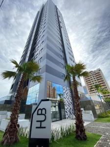 ein hohes Gebäude mit zwei Palmen davor in der Unterkunft Apartamento moderno in João Pessoa