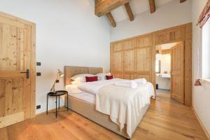 1 dormitorio con 1 cama grande y armarios de madera en Chalet SILVER FOX - Luxus Chalets, en Sankt Anton am Arlberg