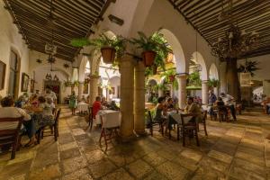 un grupo de personas sentadas en mesas en un restaurante en Hotel Meson del Marques, en Valladolid