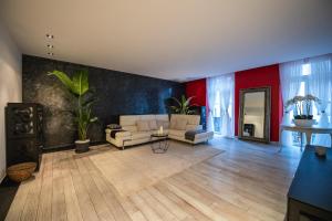un soggiorno con divano bianco e parete rossa di V APARTMENTS a Bellinzona