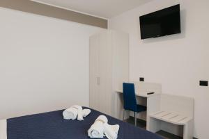 Habitación con cama, escritorio y TV. en Residence Vazzieri en Campobasso