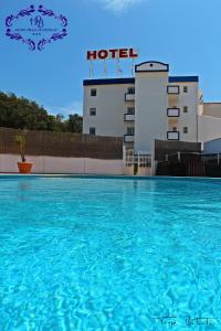 
a swimming pool with a blue sky at Hotel Burgau Turismo de Natureza in Burgau
