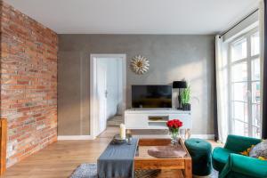 uma sala de estar com uma parede de tijolos em Bea Home Elblag - dwie sypialnie em Elblag