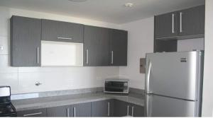 a kitchen with black and white cabinets and a refrigerator at Panoramic Ocean view Playa Blanca Suite in Playa Blanca