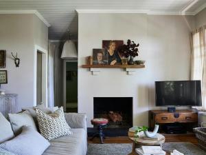 a living room with a couch and a tv at Milk and Honey in Daylesford