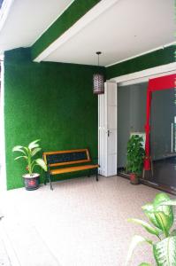 a green wall with a bench on a patio at Vinz Hotel in Malacca