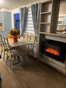 Littlestone-on-Seaholidayhome-romneysands holiday park的带桌子和壁炉的餐厅