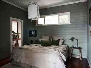 a bedroom with a large bed with green walls at Milk and Honey in Daylesford