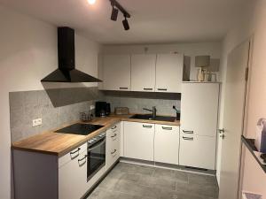 a kitchen with white cabinets and a stove top oven at Spatzennest am Taubenhaus Residenz Moselliebe in Traben-Trarbach