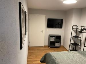 a bedroom with a bed and a television on a wall at Spatzennest am Taubenhaus Residenz Moselliebe in Traben-Trarbach