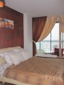 クライペダにあるKlaipeda. Old city view - 17 floorのベッドと大きな窓のある寝室