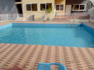 a blue chair sitting next to a swimming pool at Luxury Tema community 25 gated 3-bedroom house - Fivehills homes in Tema