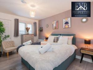 una camera da letto con un grande letto con cuscini bianchi di Stylish Southampton Abode a Southampton